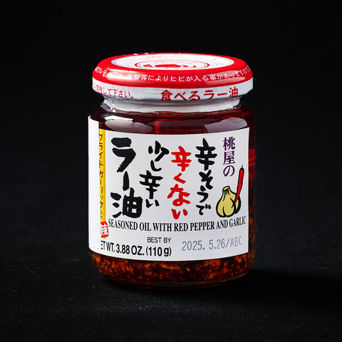 Jar of mild chilli oil on a black background