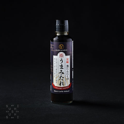 180g bottle of Umami Black Garlic Sauce on a black background