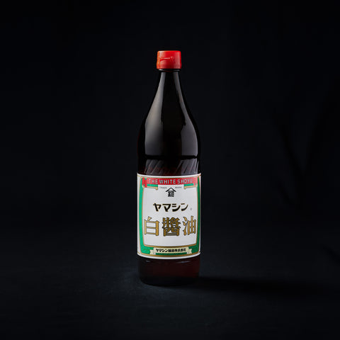 Bottle of white soy sauce on a black background