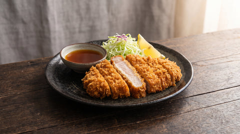 Crispy tonkatsu pork cutlet sliced and served with ponzu sauce, editorial food photography