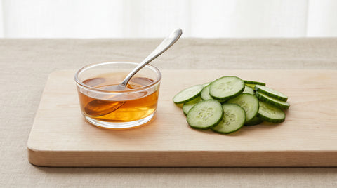Rice vinegar beside fresh cucumber slices
