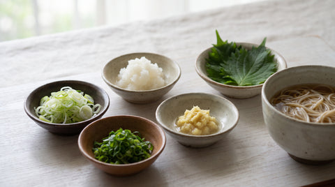 Japanese yakumi garnishes beside a bowl of noodles
