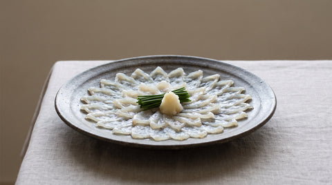 Elegantly plated fugu sashimi arranged in a flower pattern
