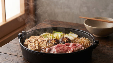 A pot of sukiyaki with beef, tofu and vegetables, editorial food photography