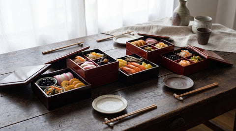 Spread of healthy Japanese New Year dishes in lacquered boxes