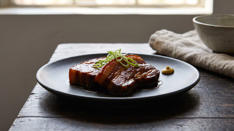 Okinawan slow-braised pork belly glazed in savoury sauce, editorial food photography