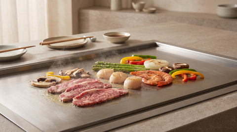 Teppanyaki grill spread with sizzling meat and vegetables