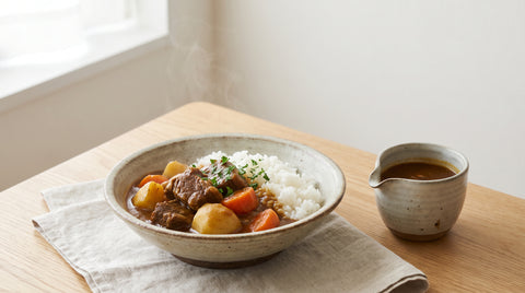 Steaming bowl of Japanese curry rice with braised meat and vegetables