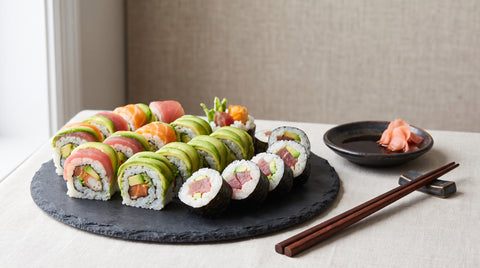 Platter of assorted colourful sushi rolls with pickled ginger and soy sauce