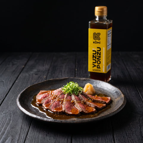 Seared beef tataki dressed with Kōmi Yuzu Ponzu, 300ml bottle behind
