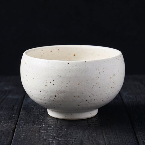 White matte glaze barrel-shaped bowl with brown flecks