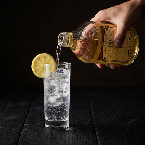 Kannoko barley shochu served oyuwari in a glass beside the 720ml bottle