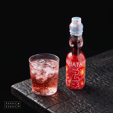 Hata Strawberry Ramune 200ml, bottle beside a glass of ramune over ice