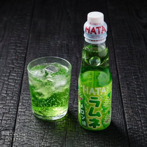 Hatakosen Melon Ramune 200ml, bottle beside a glass of melon ramune over ice