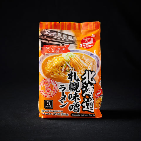 Orange packet of noodles on a black background
