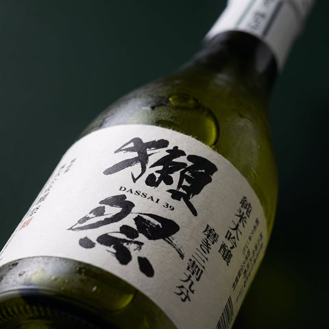 Dassai 39 Junmai Daiginjo sake label close up detail, glass and text texture