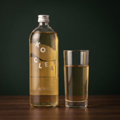 Koji Clear rice koji drink poured into a glass beside the 700ml bottle, lifestyle serve