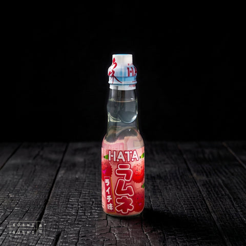 Hata Lychee Ramune 200ml, bottle on charred shou sugi ban wood against a black background