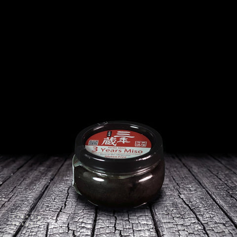 Ishiimiso, Sannengura Three Years Miso, 300g, tub on charred shou sugi ban wood against a black background