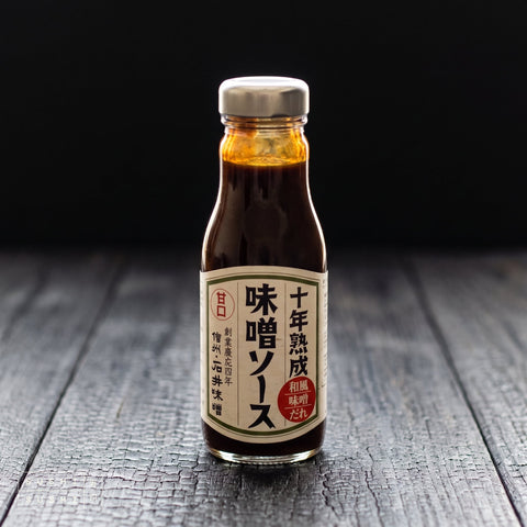 Ishiimiso, Ten-Year Aged Miso Sauce 260g, bottle on charred wood