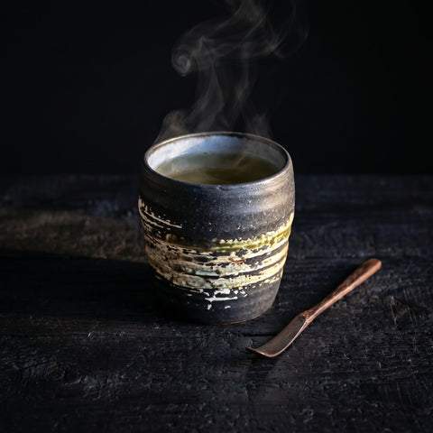 Black handleless Japanese ceramic cup, side view