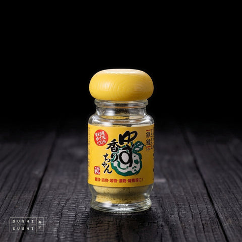 Kagura, Powdered Yuzu Zest, 25g, jar on charred shou sugi ban wood against a black background