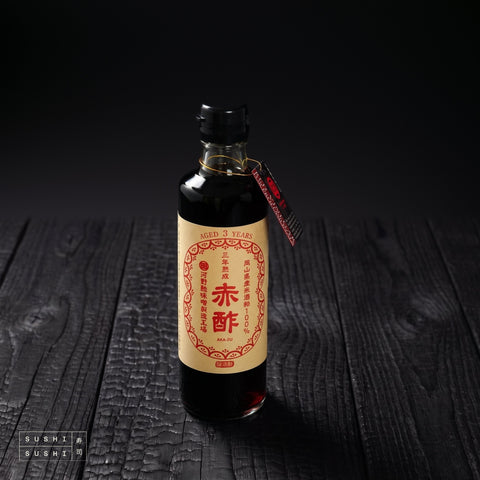 Kono, Pure Japanese Akasu Vinegar, 275ml, bottle on a charred shou sugi ban wooden surface against a black background