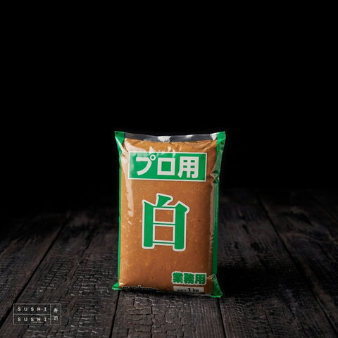 Marukome, White Miso Paste (Shiro Miso), 1kg, pack on charred shou sugi ban wood against a black background