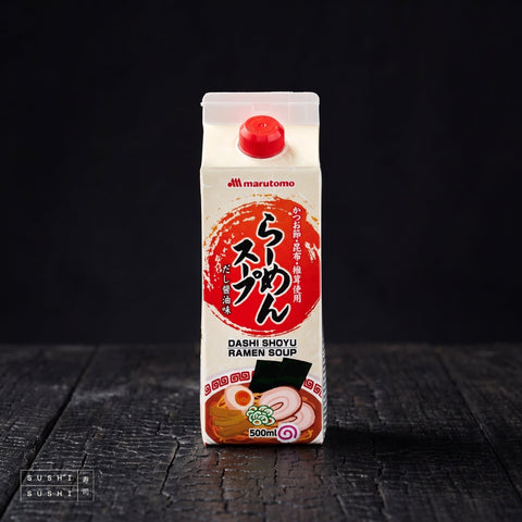 Marutomo, Shoyu Ramen Soup Concentrate, 500ml, carton on charred wood against black