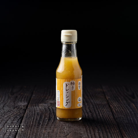 SAIKA Yuzu Dressing 150ml, bottle on a charred shou sugi ban wooden surface against a black background
