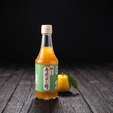 Saika, Yuzu Sushi Vinegar, Seasoned Rice Vinegar with Yuzu Citrus, 300ml, bottle with a fresh yuzu on charred shou sugi ban wood