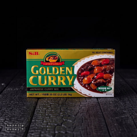 S&B Golden Curry Medium Hot 1kg, carton on a charred wood surface