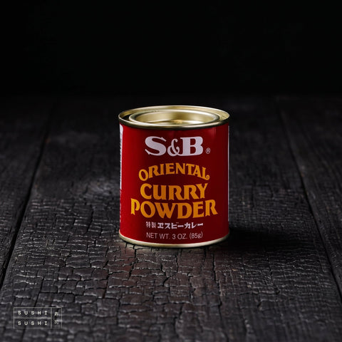 S&B, Japanese Curry Powder, 85g, tin on a charred wood surface