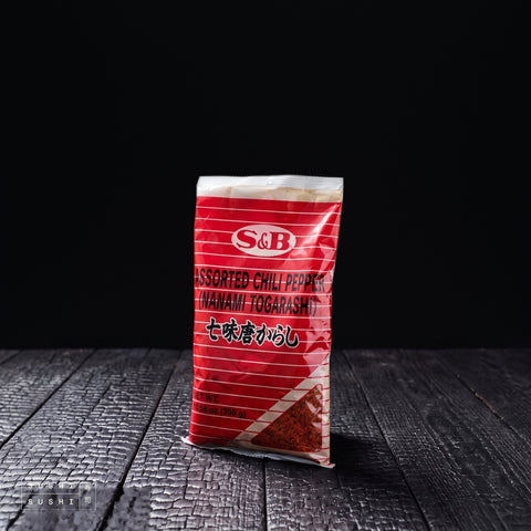 S&B, Shichimi Togarashi, 300g, bag on a charred shou sugi ban wooden surface against a black background