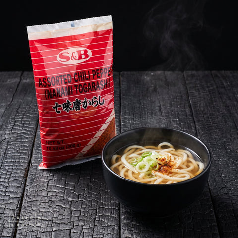 S&B, Shichimi Togarashi, 300g, beside a bowl of udon finished with shichimi