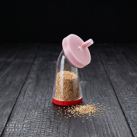 Slicky-N Sesame Seed Grinder, filled with toasted sesame on charred wood