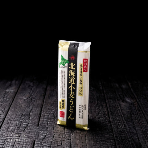 Toa, Premium Hokkaido Wheat Dried Udon Noddles, 300g, pack on charred shou sugi ban wood against a black background